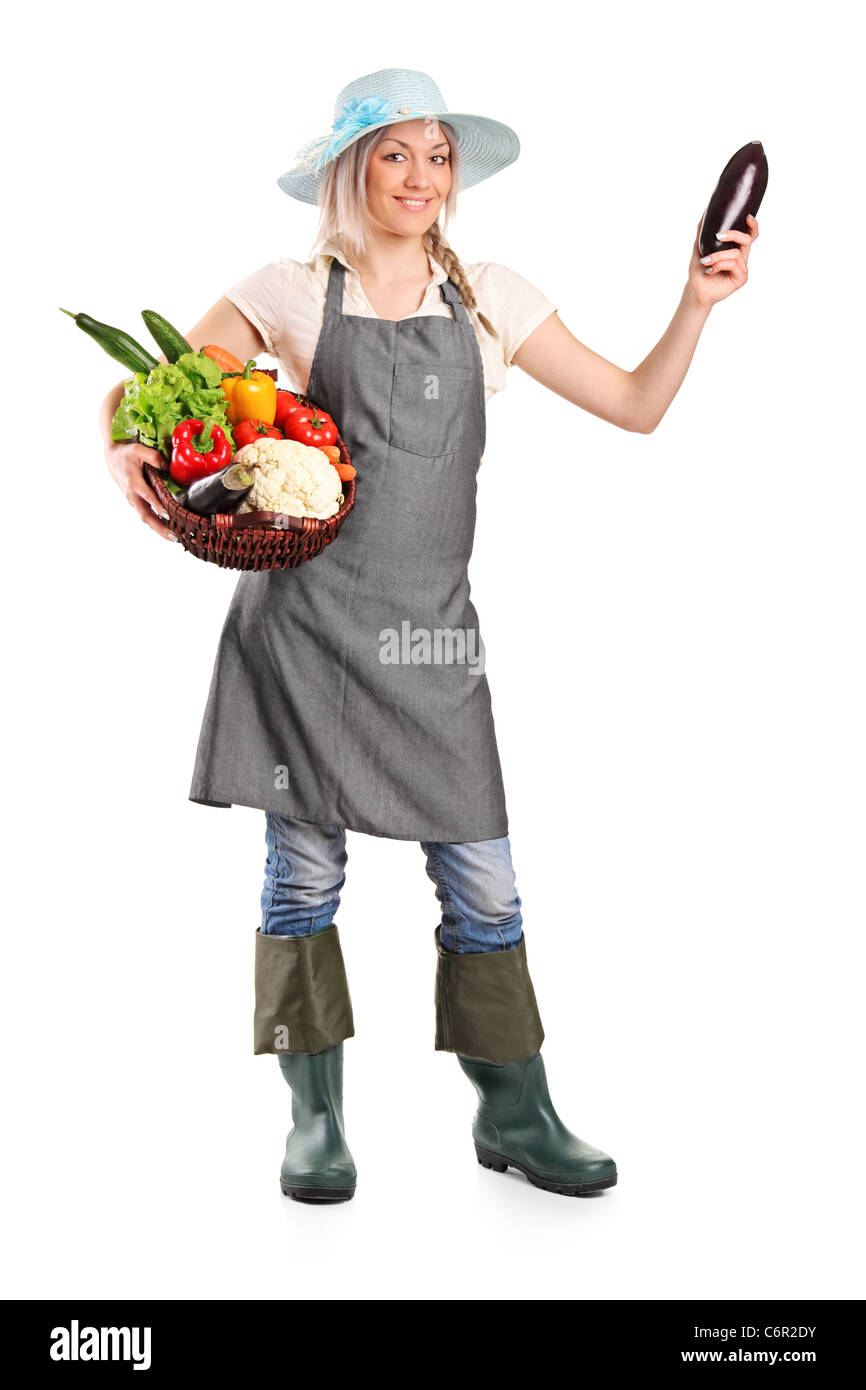 Full length portrait of a smiling female farmer holding various ...