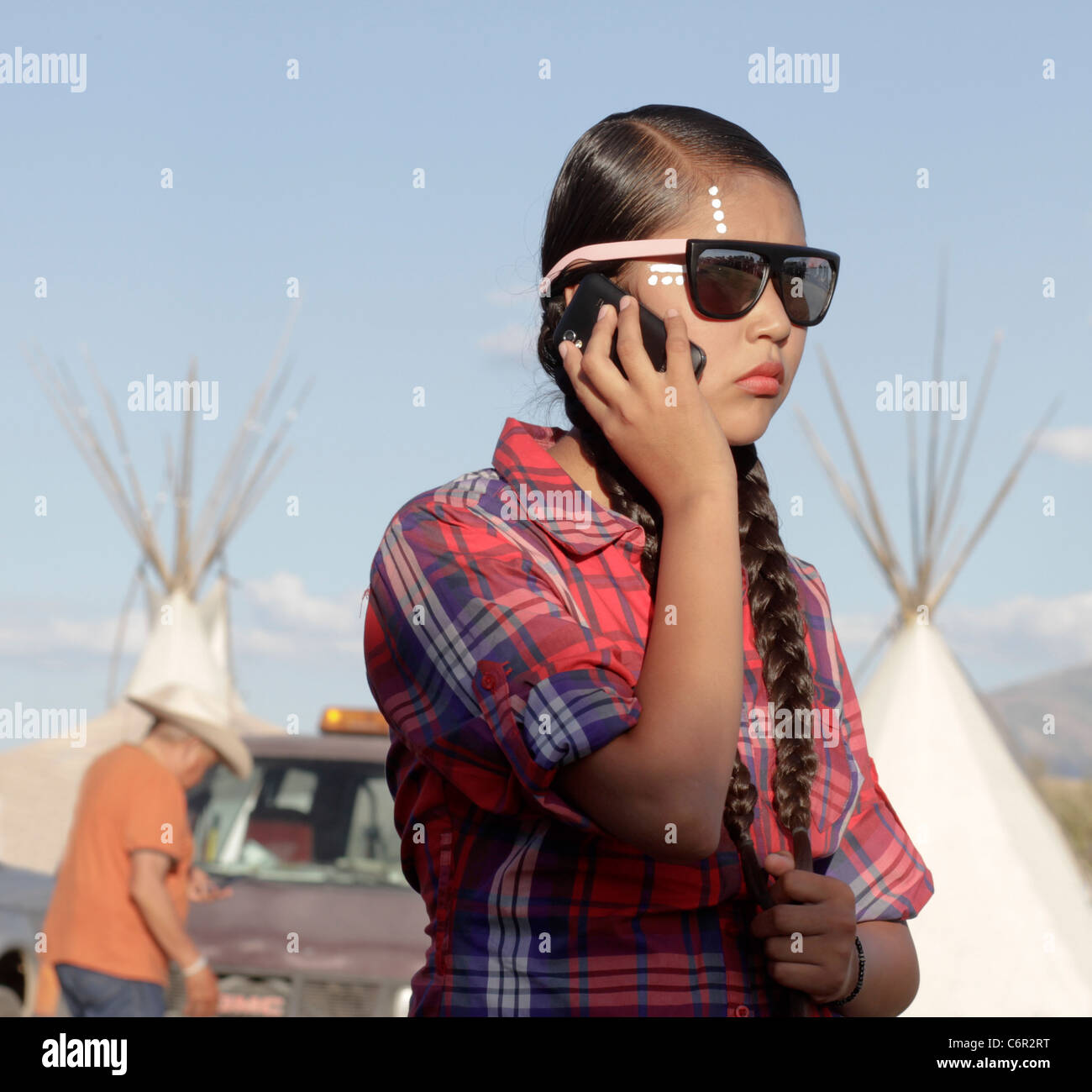 Young Native American woman in Ft Hall, Idaho, using a mobile phone before taking part in a powwow. Stock Photo