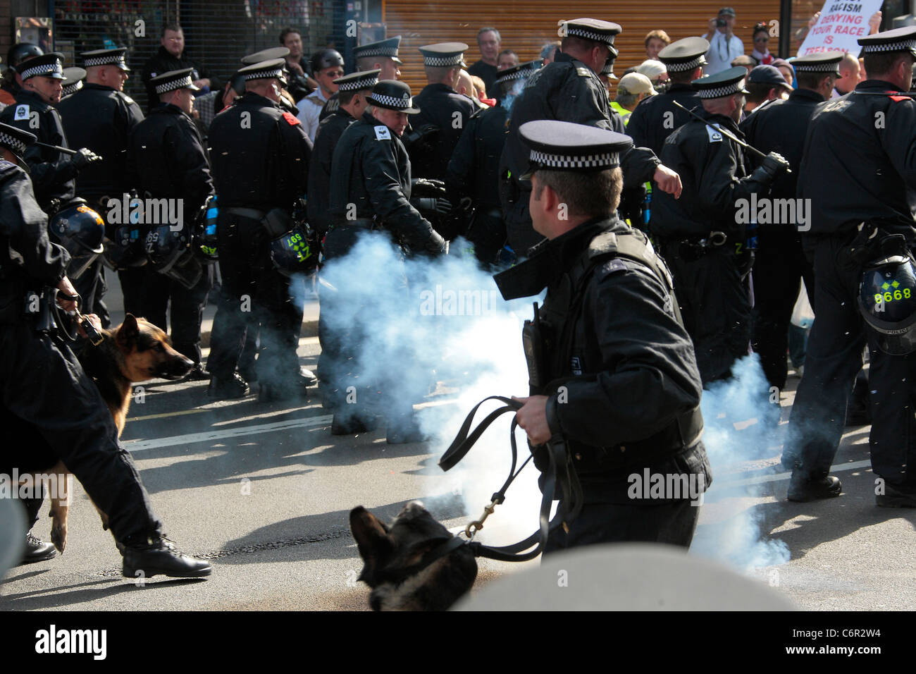 Thunder flash explodes near a police dog during a demonstration by the EDL in London Stock Photo