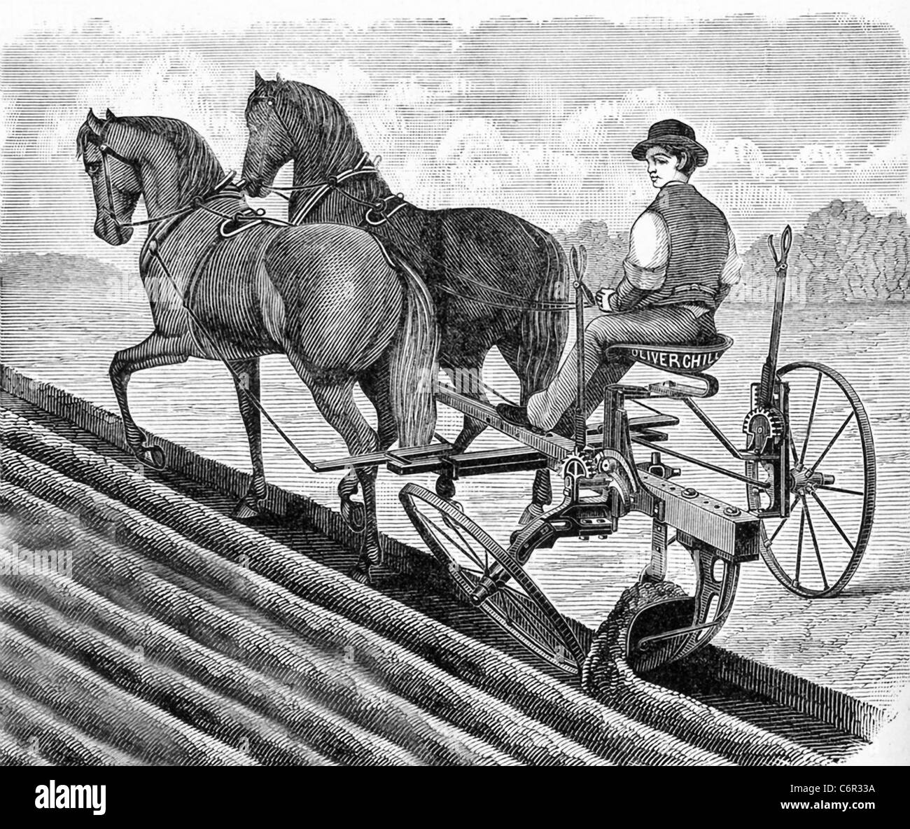 In the 1840s, a new version of the sulkey plow had wheels and a seat for the plowman. The lettering  says Oliver Chill[ed Plow. Stock Photo