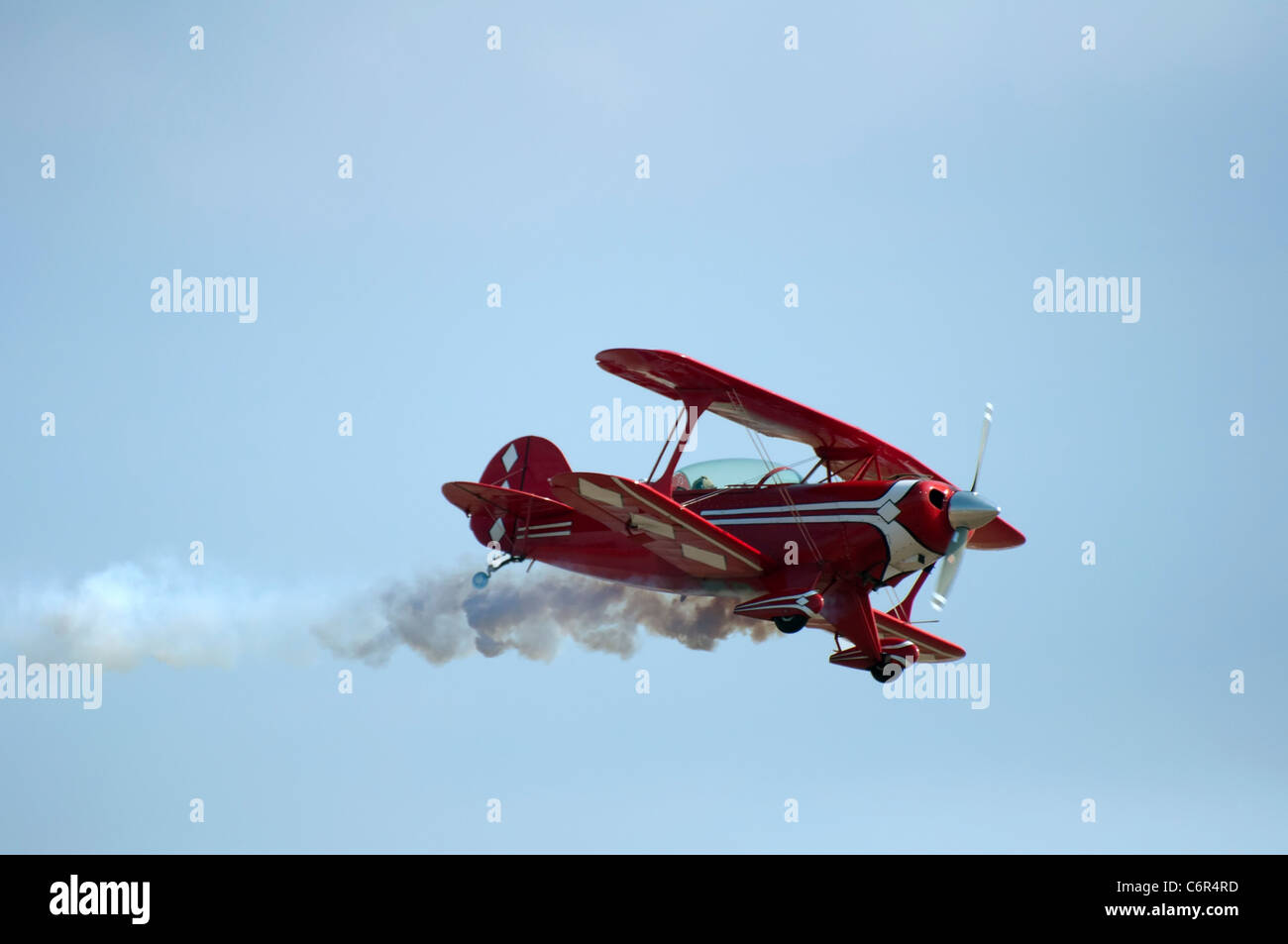 Red plane looping in a blue sky. Close up Stock Photo