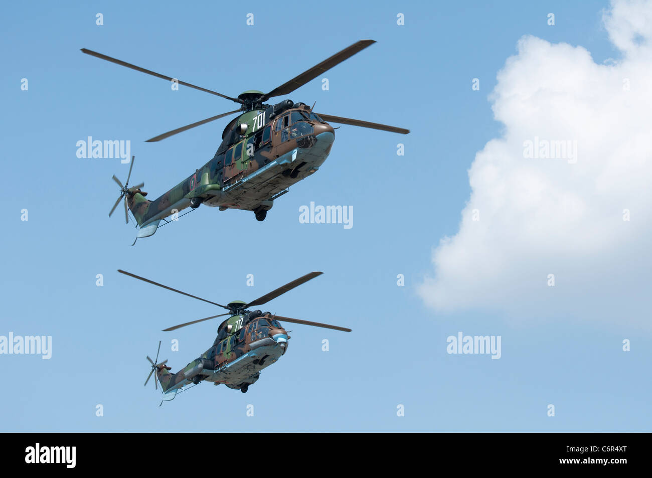 Two green military helicopters on blue sky background Stock Photo