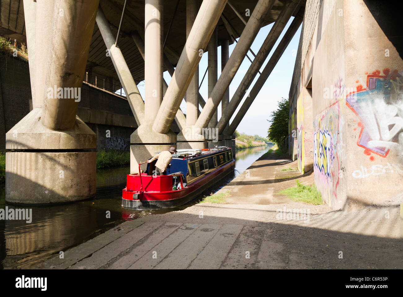 Narrow boat passing below the motorway in the West Midlands Stock Photo