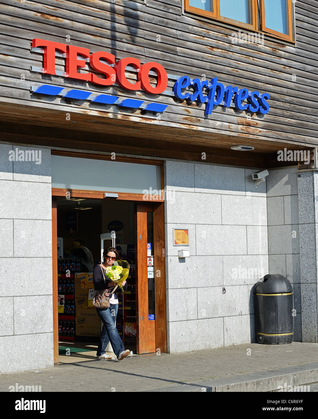 A customer coming out of Tesco express shop, UK Stock Photo