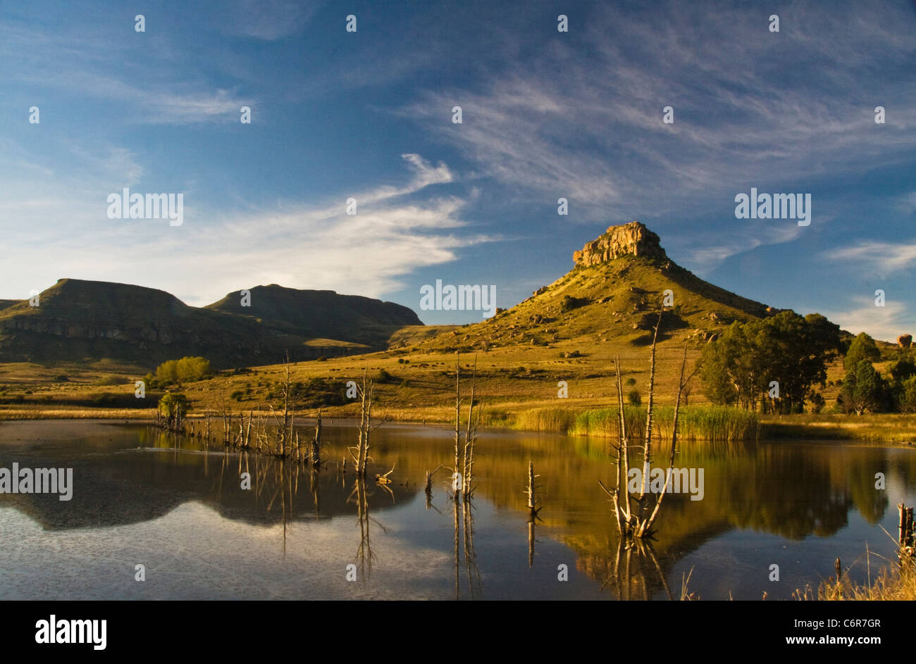 Clarens scenery showing a distant sandstone koppie with a dam in the foreground Stock Photo