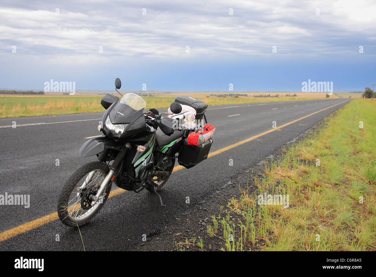 Tar road in remote landscape with motorcycle Stock Photo
