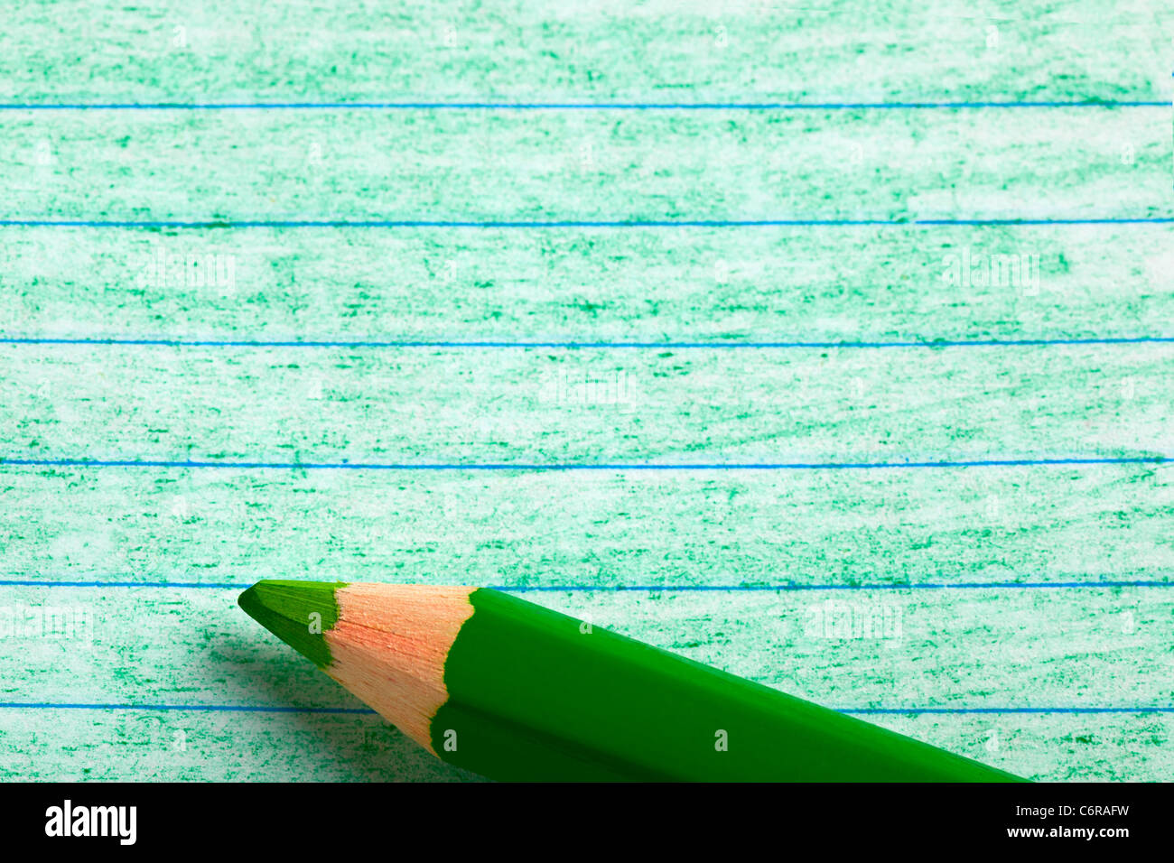 Green color pencil with coloring on a piece of writing paper Stock Photo