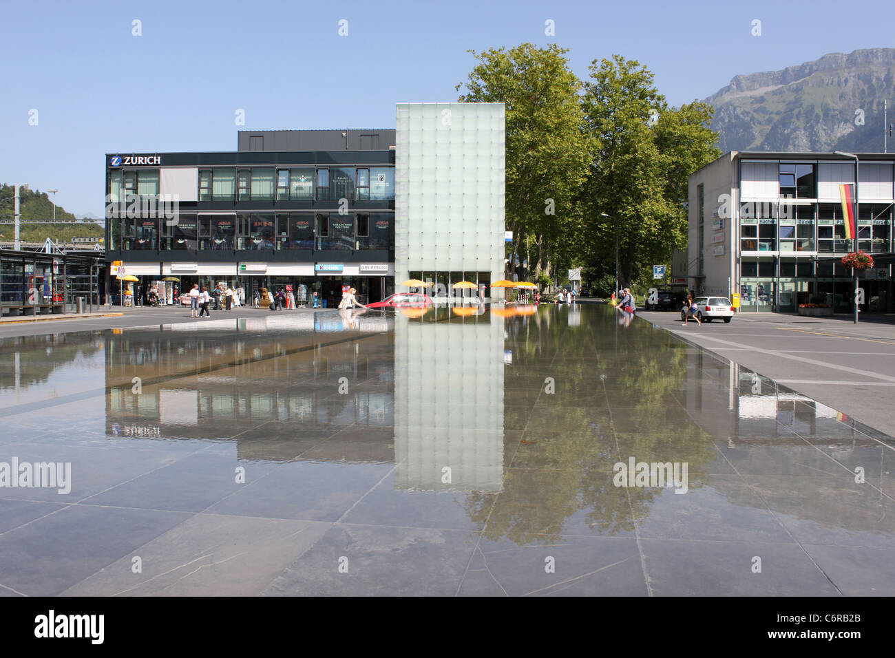 Water feature outside Interlaken Ost railway station with reflections of buildings and shops