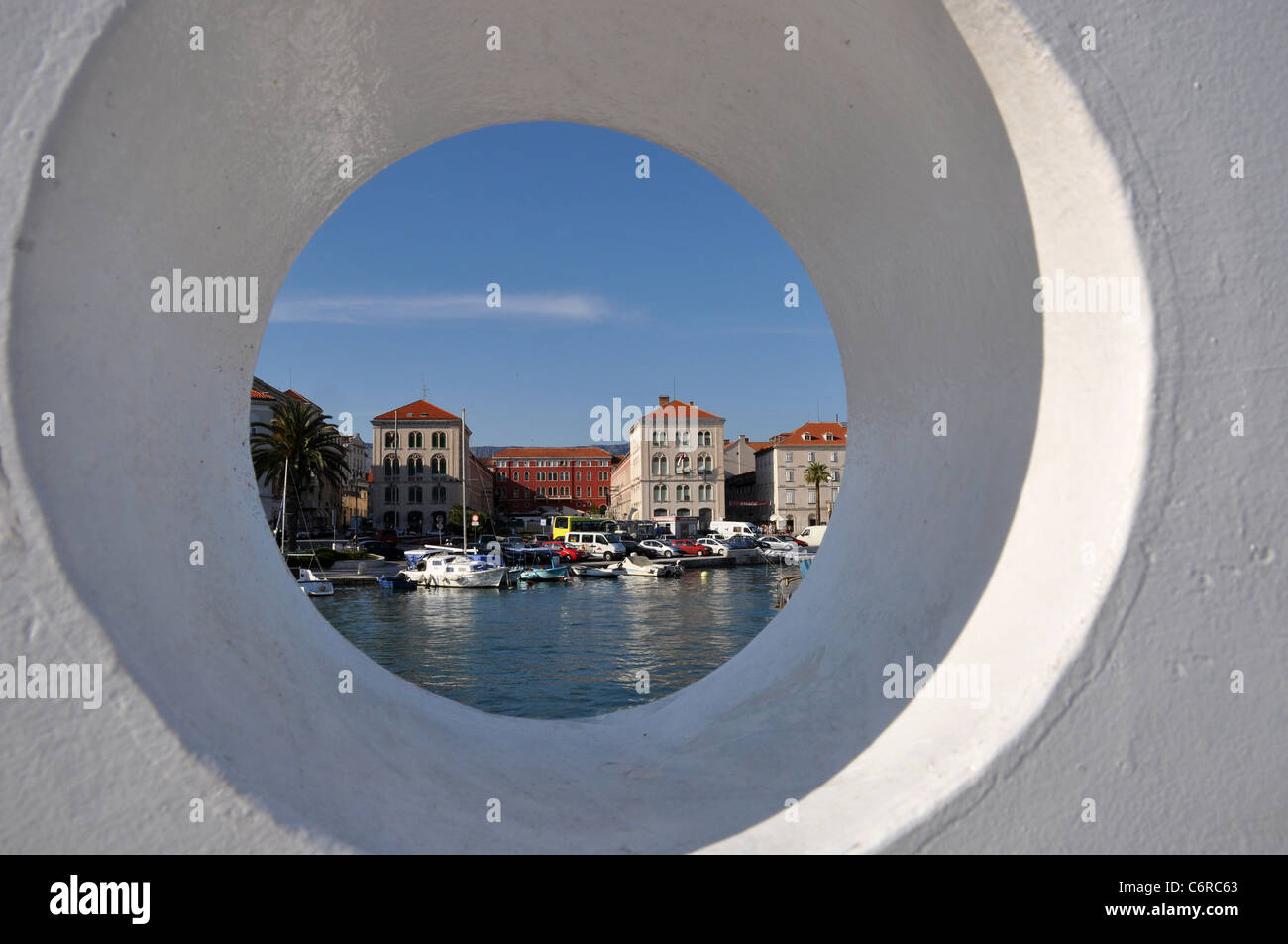 View on harbor through a hole in a wall Stock Photo