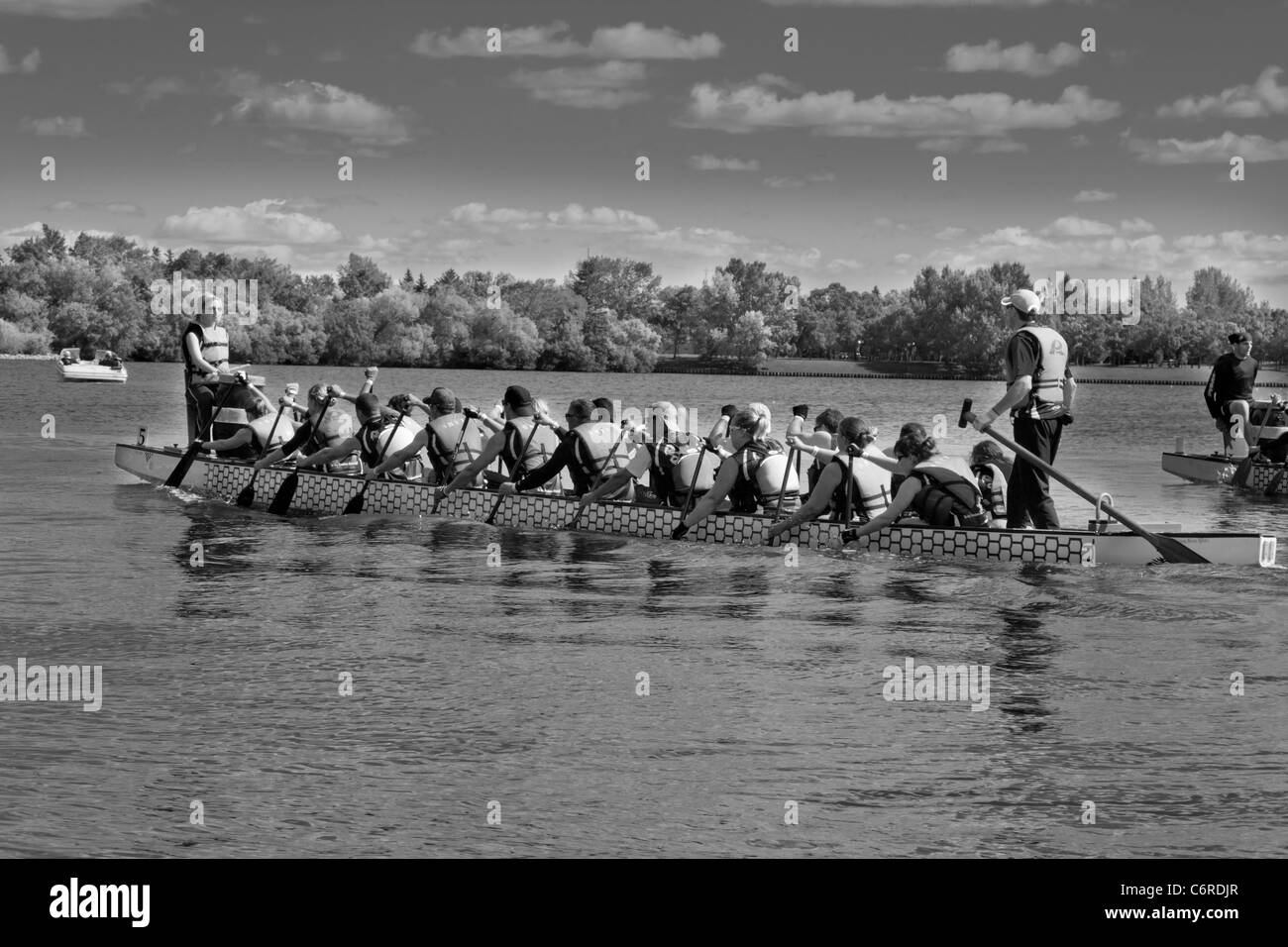 A team of dragon boat racers paddling their boat Stock Photo