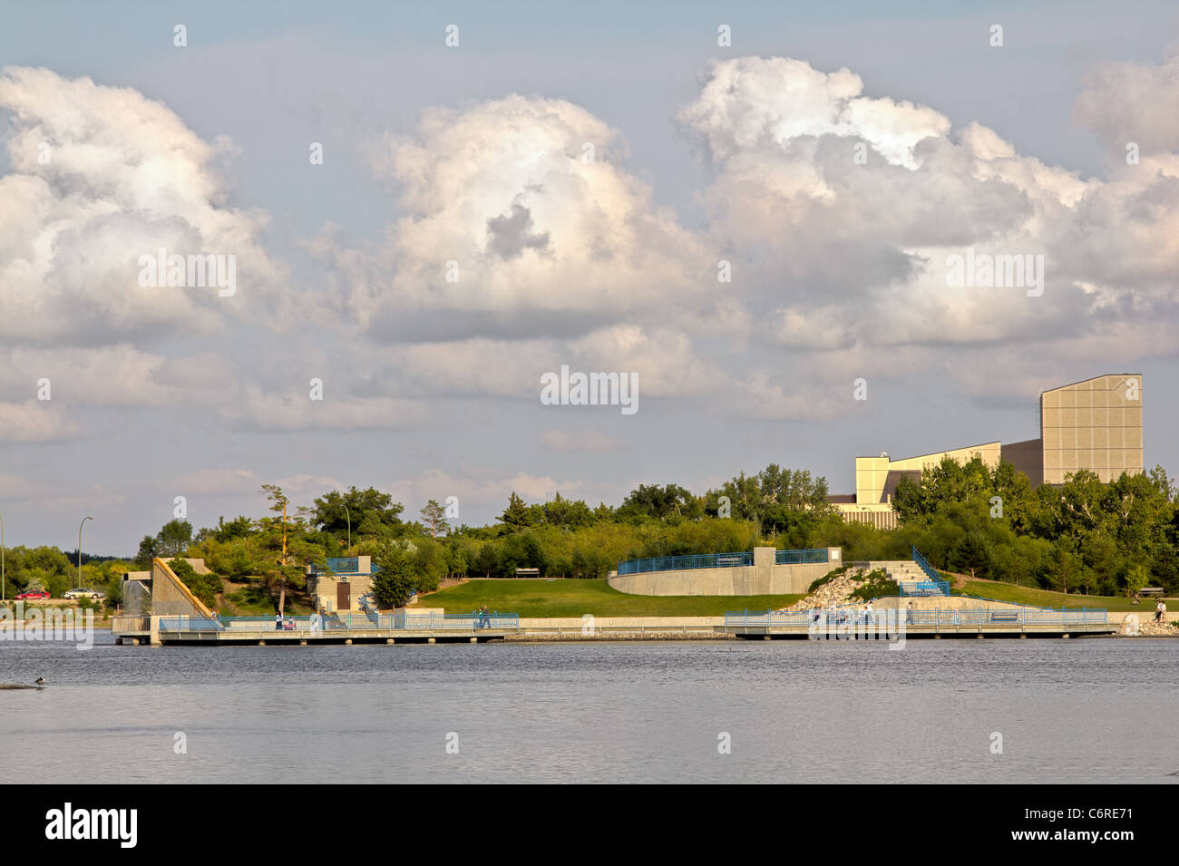 The beautiful Wascana lake on a bright sunny day with trees and a building in the background. Stock Photo