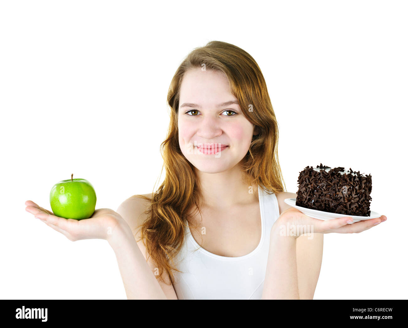 Smiling young woman holding apple and chocolate cake Stock Photo