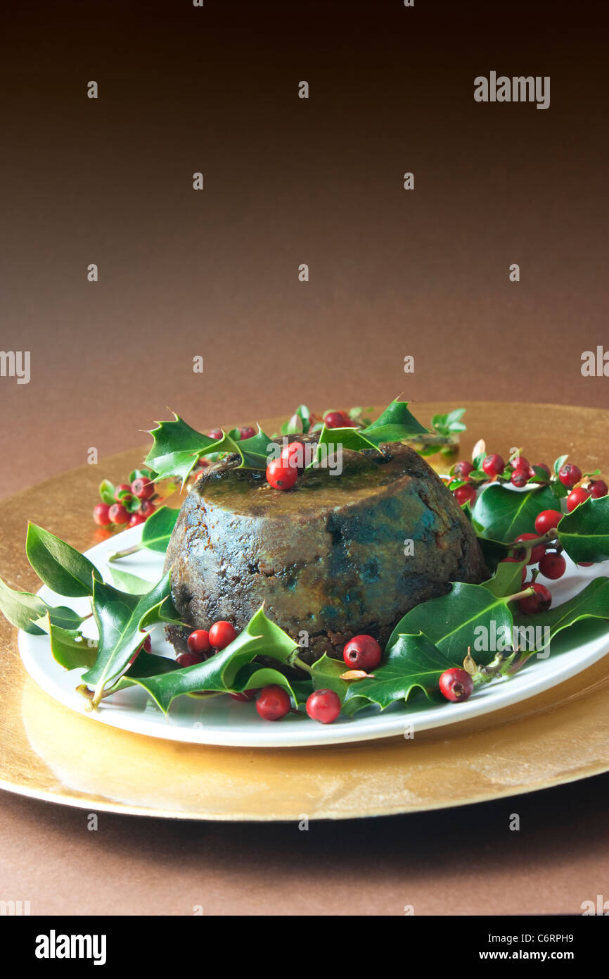 christmas pudding with holly and red berries on brown background Stock Photo
