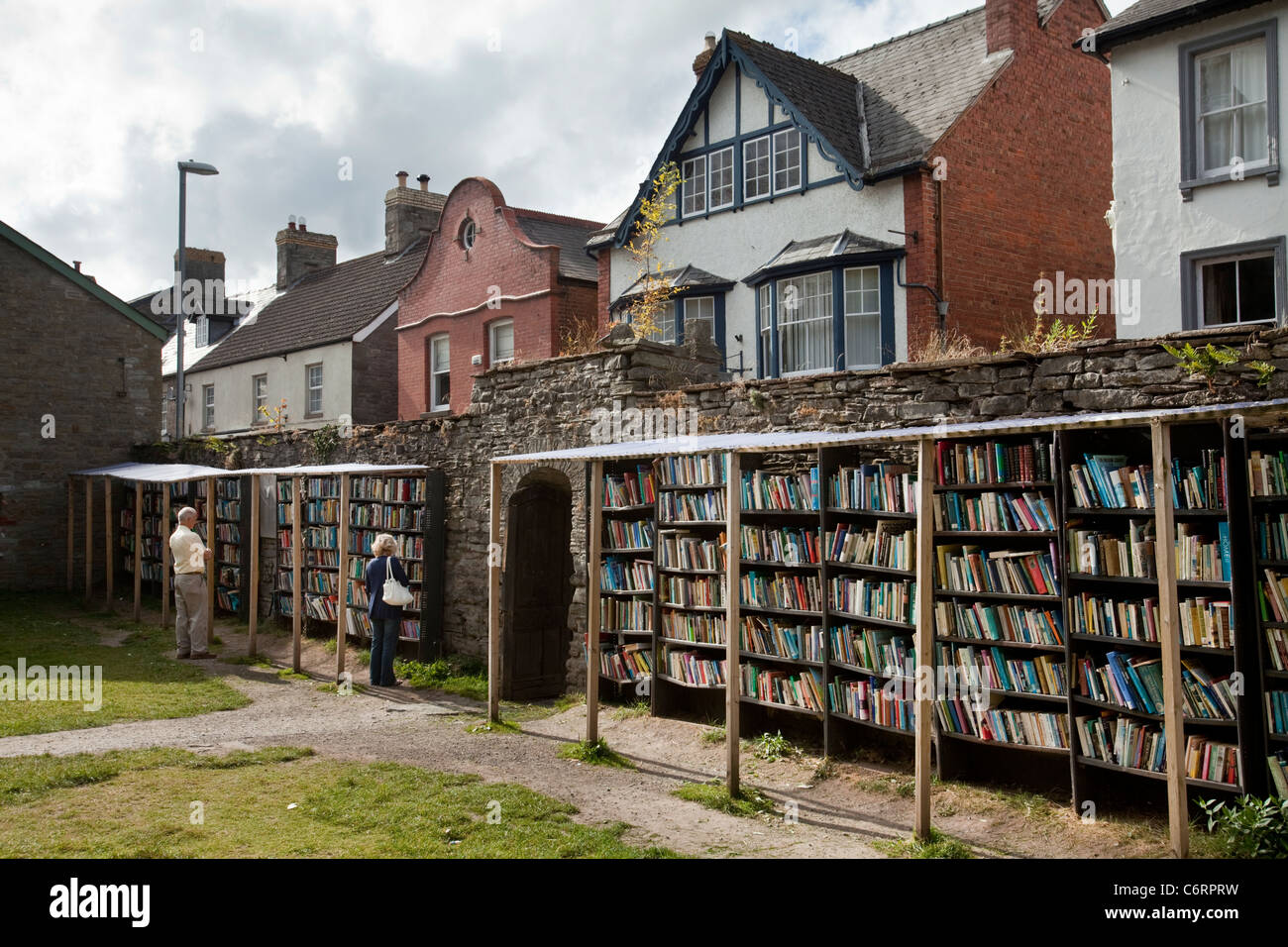 Two people browsing at an honesty bookshop in the grounds of Hay Castle in Hay-On-Wye, UK Stock Photo