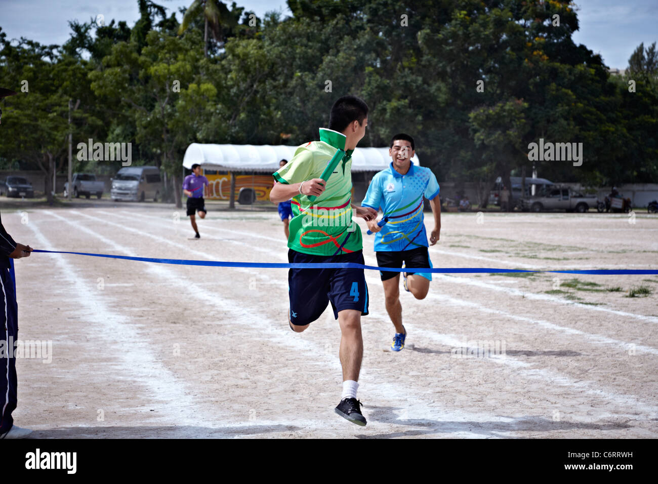 Winner crossing the finishing line at an Asian school sports day event. Thailand S. E. Asia Stock Photo