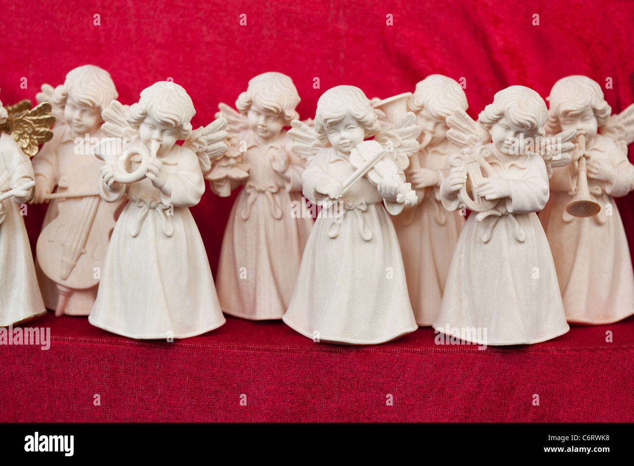 A set of angel statuettes playing various musical instrument. Focus on the central angel with a violin. Stock Photo