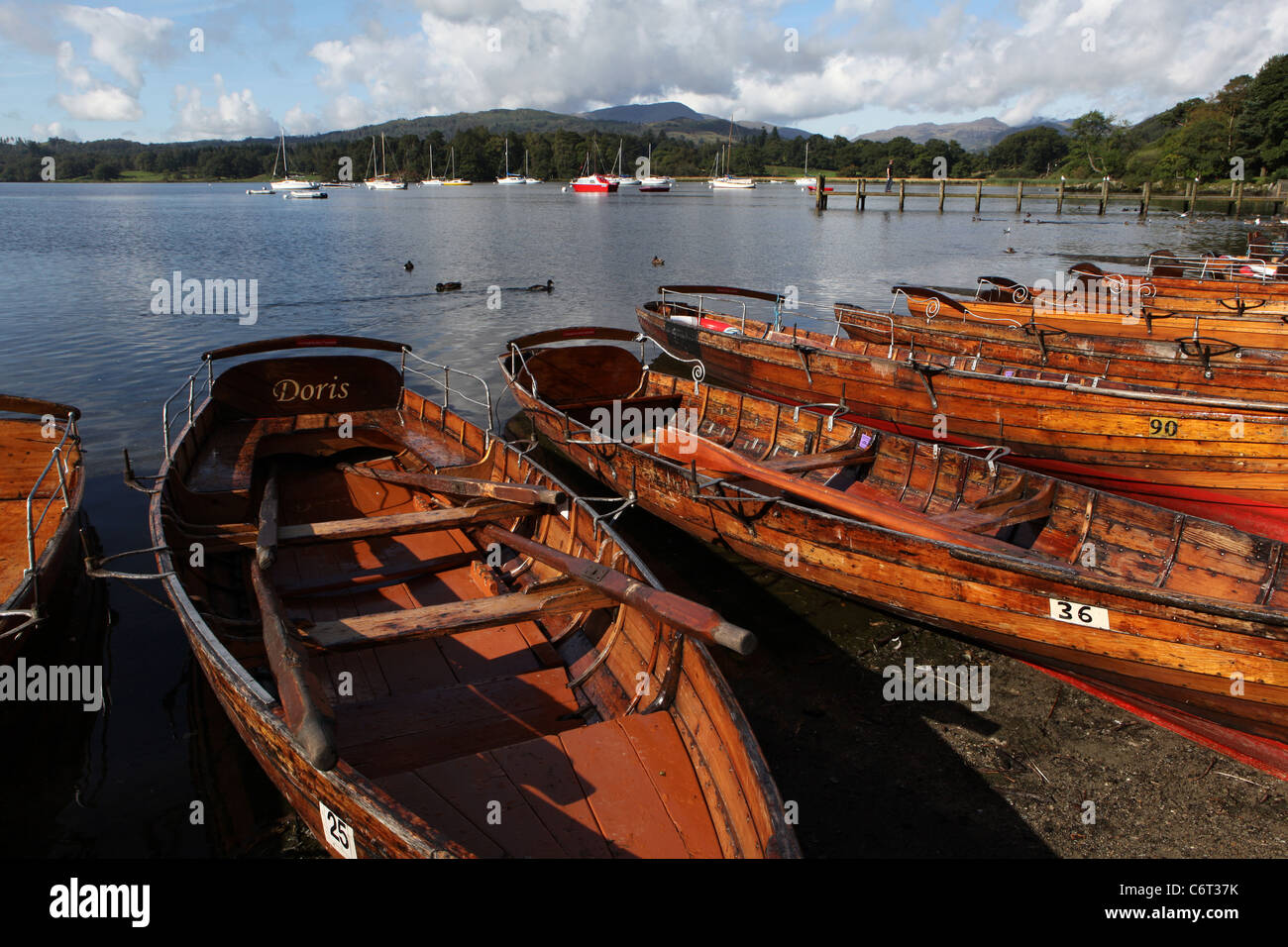 [Rowing boats] and [sailing yachts] in morning sun on [Lake Windermere