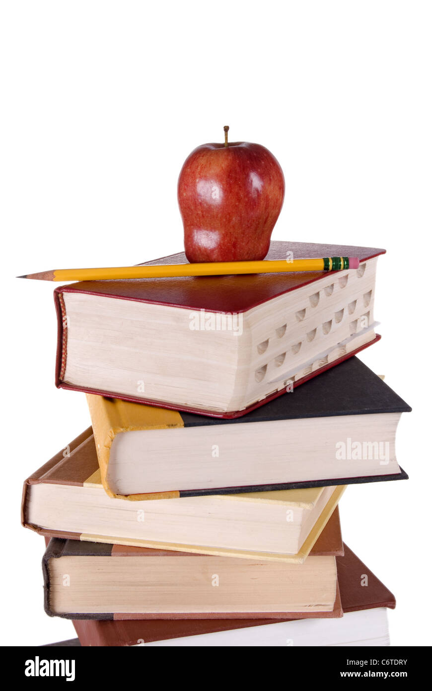 Stack of colorful hardbound books stacked vertically with a red apple and yellow pencil on the top book. Stock Photo
