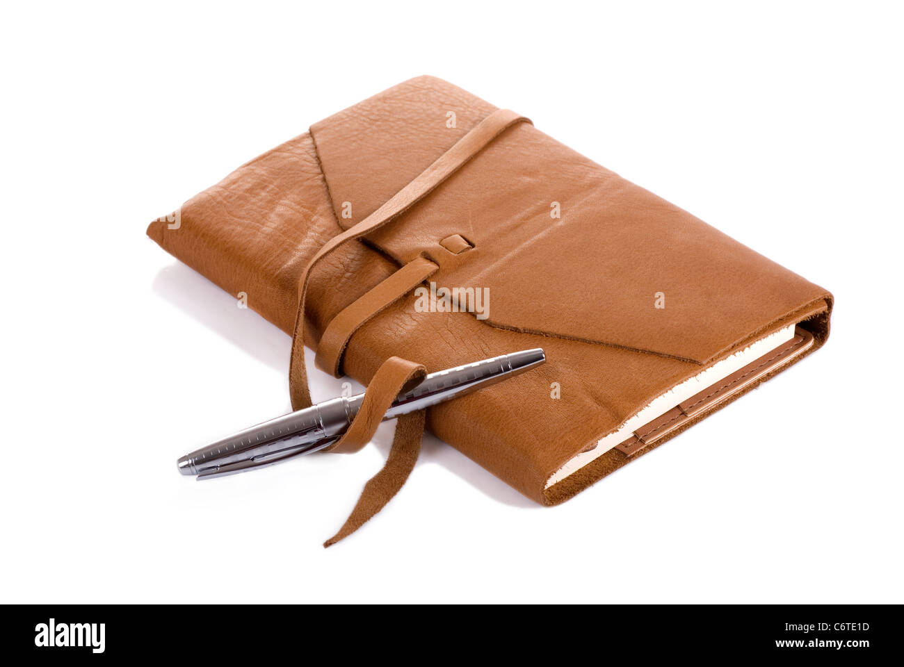 Horizontal image of a leather covered notebook and a silver pen with shadow against a 255 white background. Stock Photo