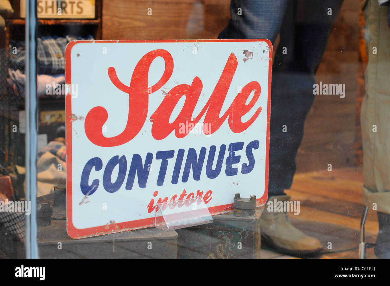 Sale Continues instore sign in shop window. Stock Photo