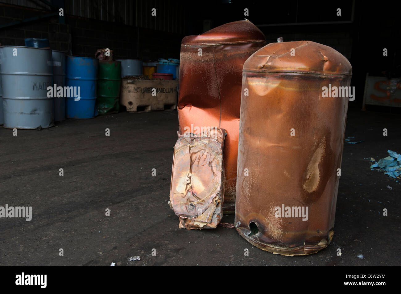 Scrap metal waiting to be recycled. Copper water immersion tanks. At the front standing up is one that has been crushed. Stock Photo