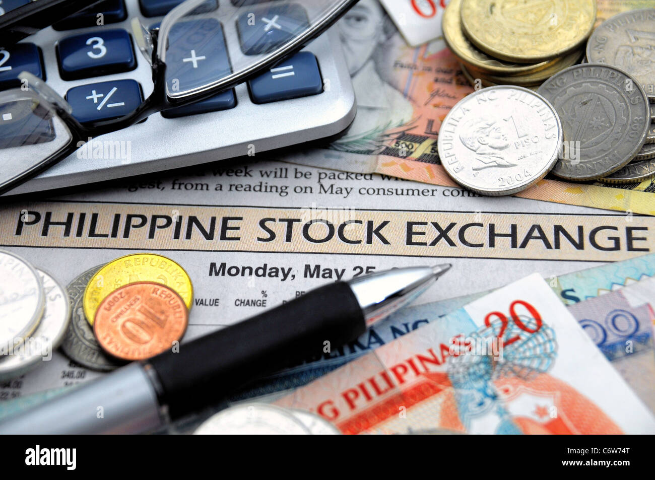 Currency from Philippines - Various banknotes and coins on a stock market report. Philippine Pesos! Stock Photo