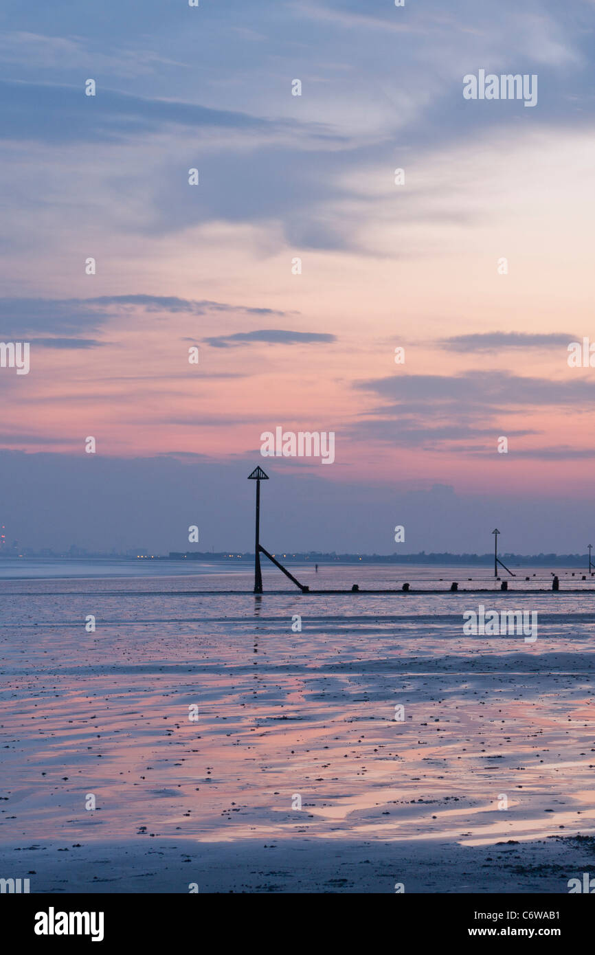 Sunset on coast at West Wittering with groynes. Stock Photo
