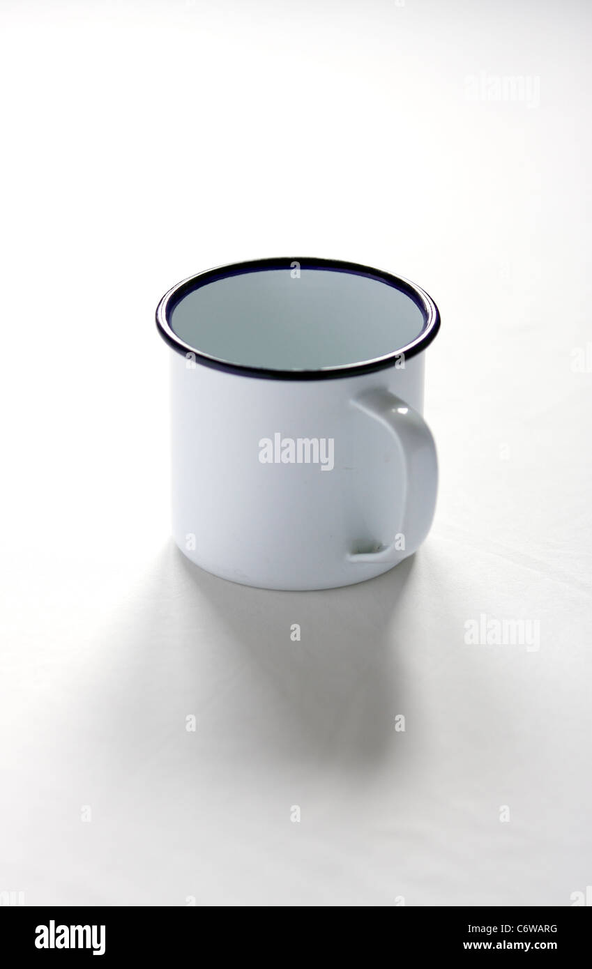 Empty white enamel mug with a blue stripe on the rim Stock Photo