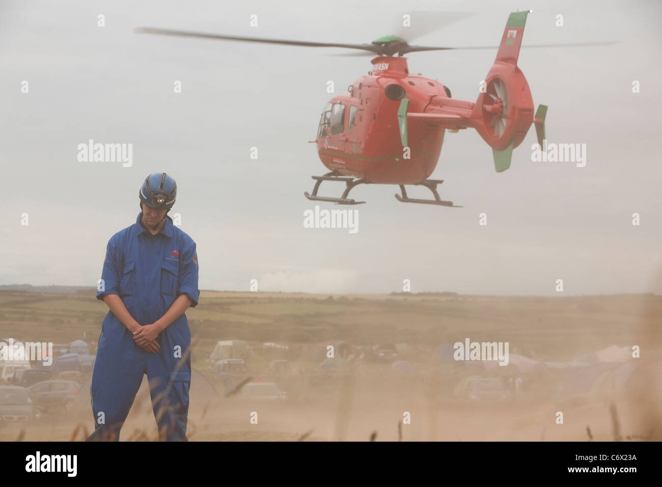 Coastguard Rescue Service volunteer oversees wales air ambulance taking off at Hillend Camping site, Llangennith, Gower Stock Photo