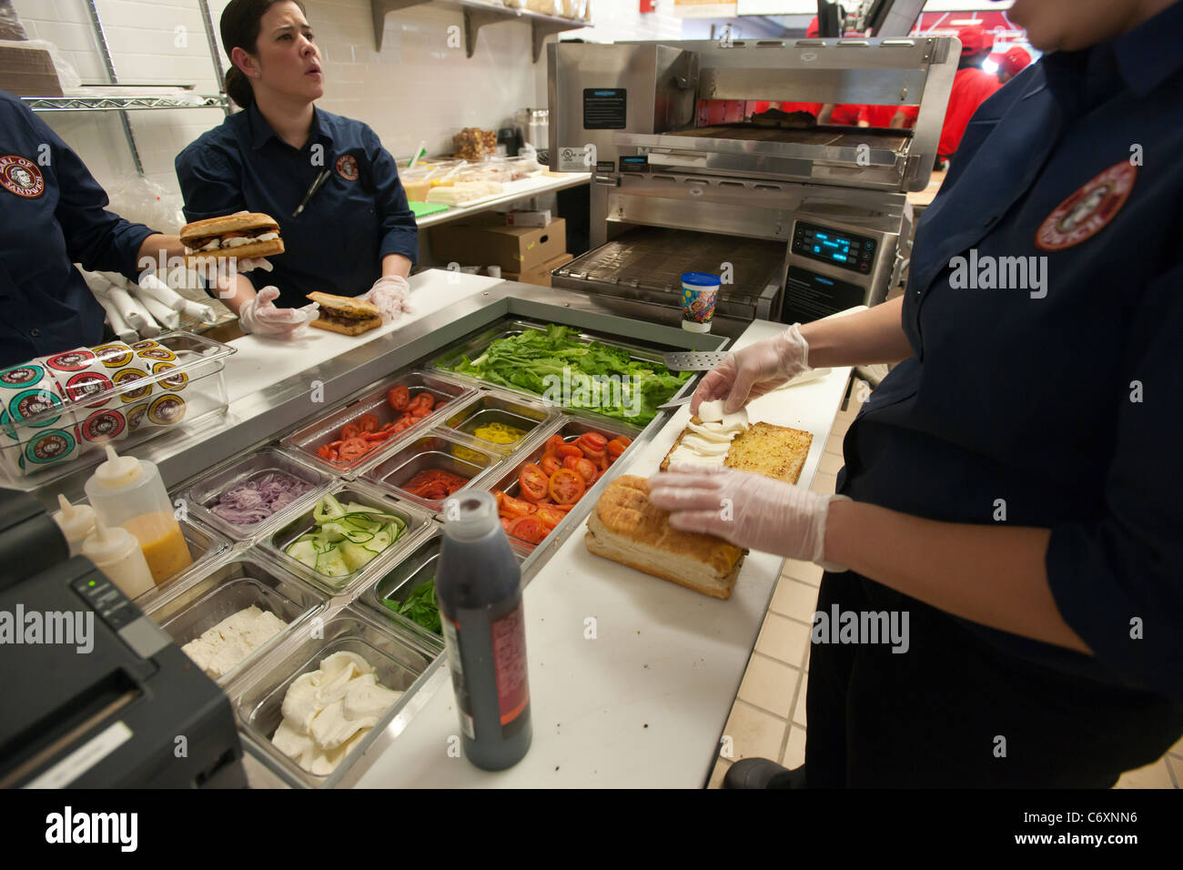 Workers prepare sandwiches at the Earl of Sandwich opening of their