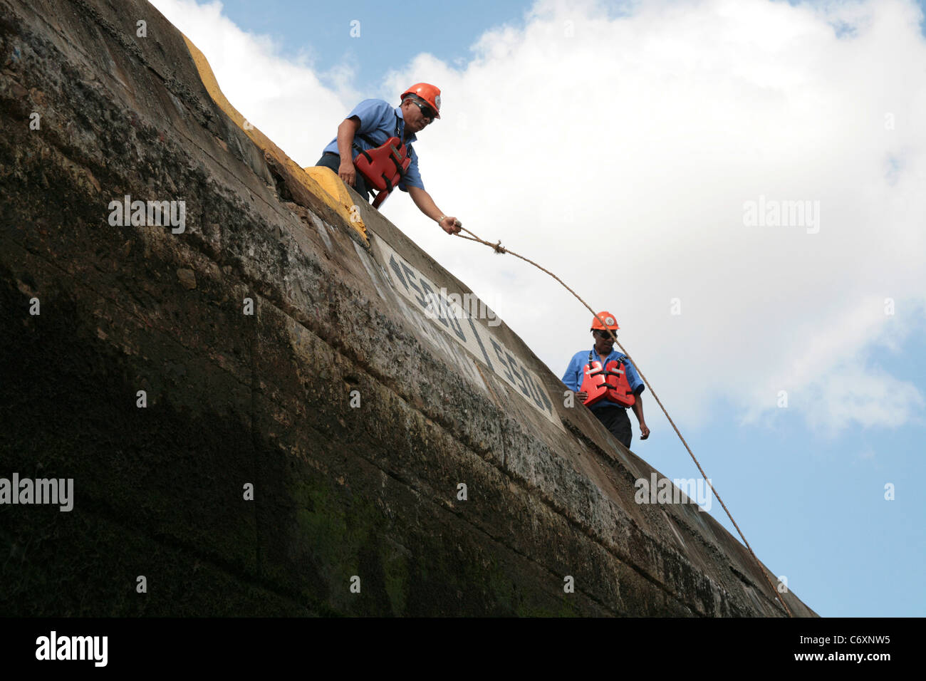 Panama Canal workers handling ship lines at the Miraflores Locks. Stock Photo