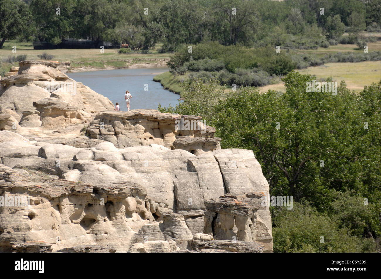People standing on hoodoos at Writing on Stone Provincial Park, Alberta, Canada Stock Photo