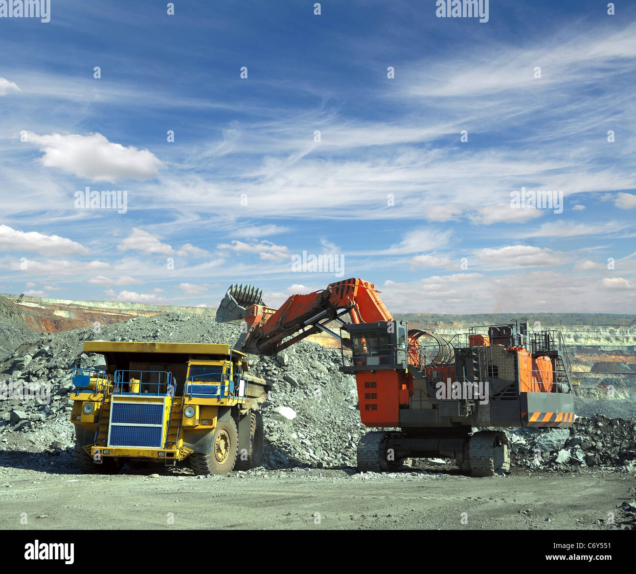 Loading of iron ore on very big dump-body truck Stock Photo