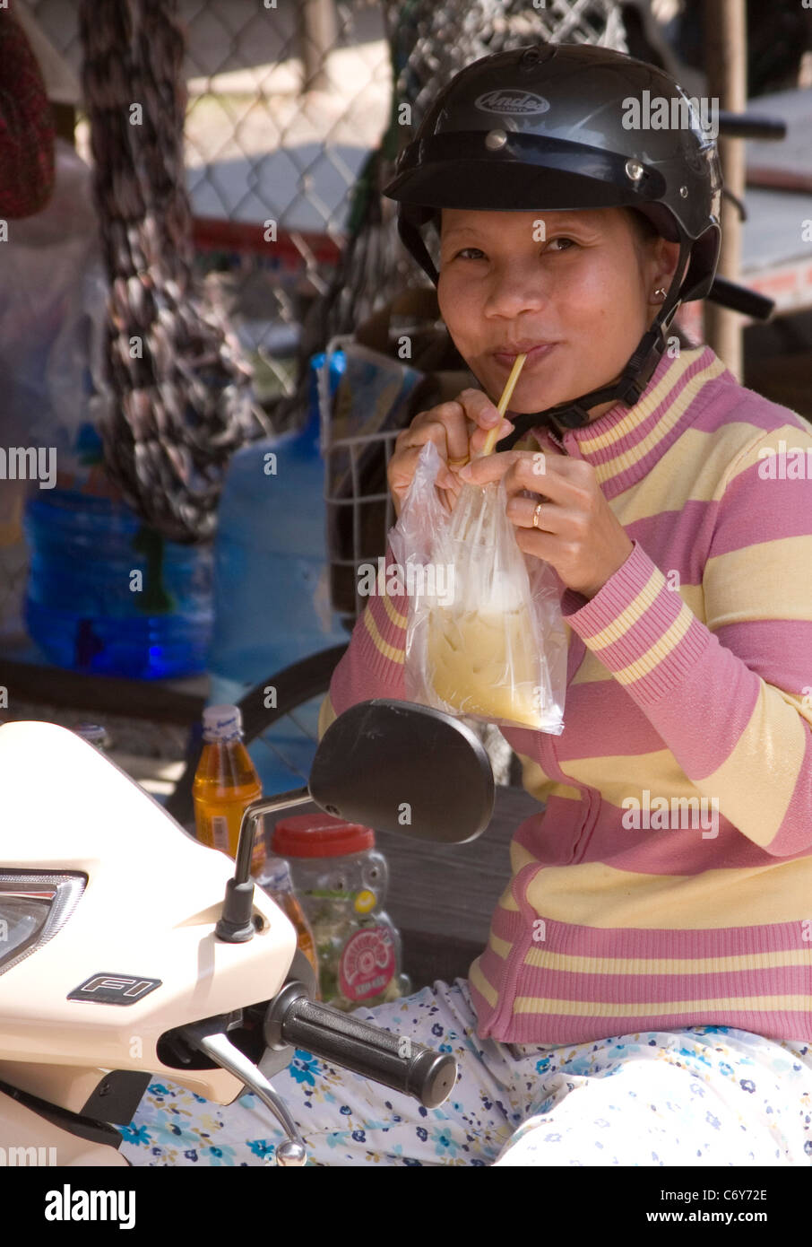 Vietnamese girl drinks her 'take away' soda Stock Photo