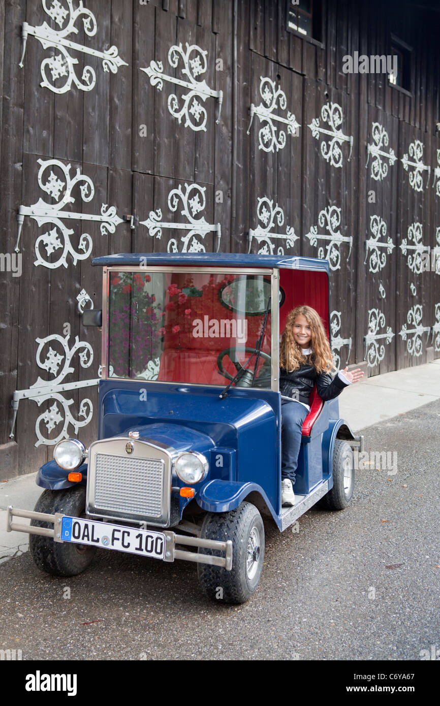 Blond girl driving funny little classic car Stock Photo