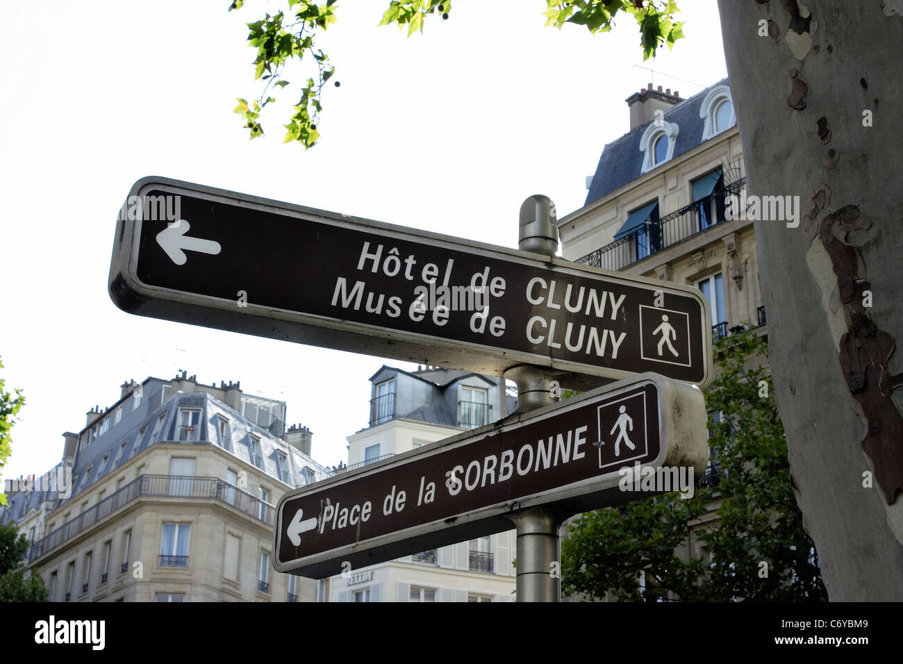A street sign in Paris showing directions to the Sorbonne and Musee de