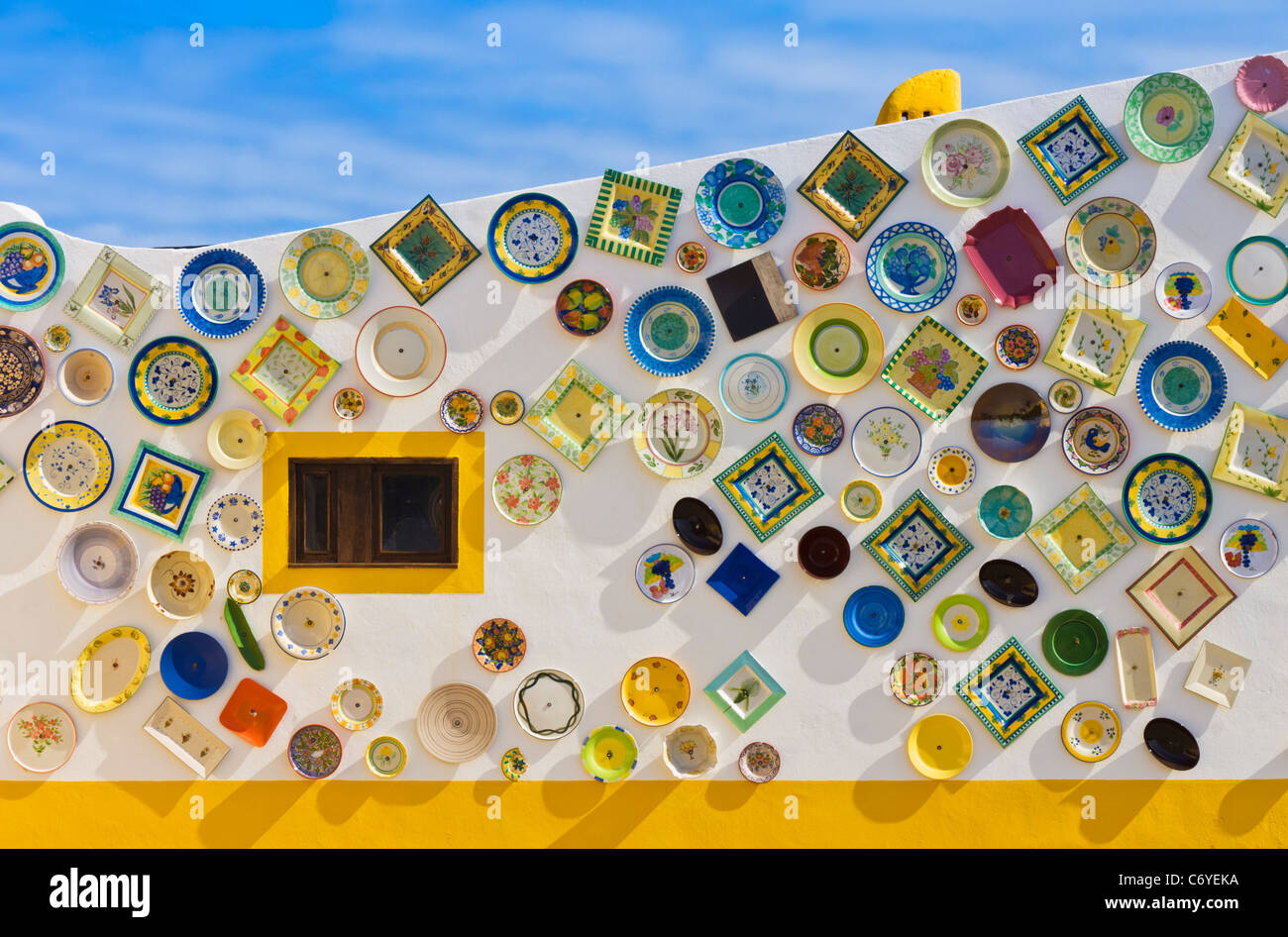 Portuguese Traditional Pottery with decorated plates and dishes attached to the wall outside the design studio Sagres Algarve Portugal EU Europe Stock Photo