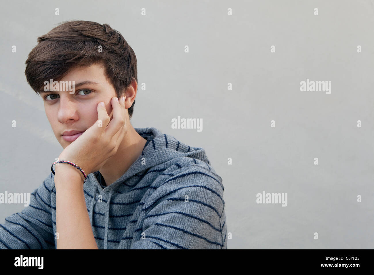 Teenage boy resting chin in hand Stock Photo Alamy