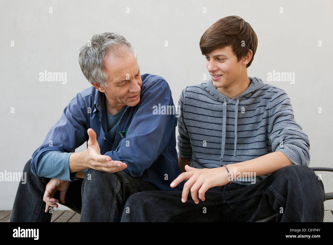 Father and son sitting together Stock Photo - Alamy