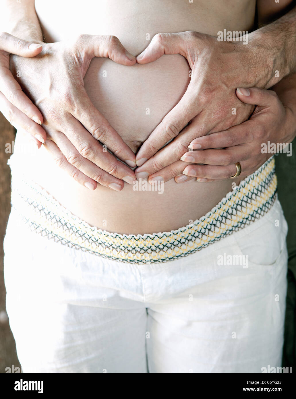 Couple holding woman's pregnant belly Stock Photo