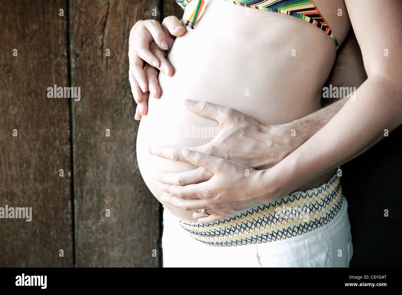 Couple holding woman's pregnant belly Stock Photo