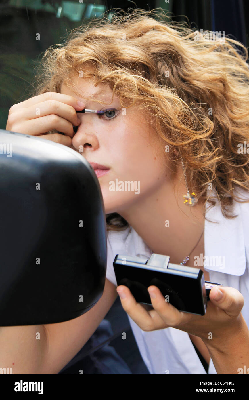 Woman applying makeup in car mirror Stock Photo Alamy