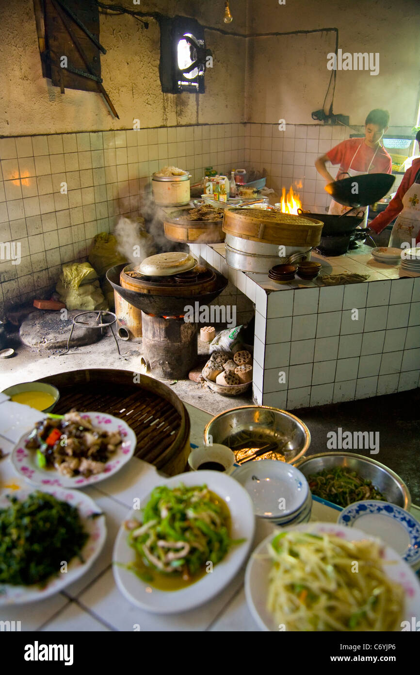 Busy hot messy untidy local & cheap kitchen serving delicious genuine ethnic Chinese cooking / cooked food meals / meal in Sichuan. China. (125) Stock Photo