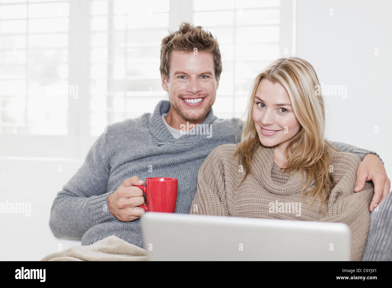 Couple relaxing together on couch Stock Photo