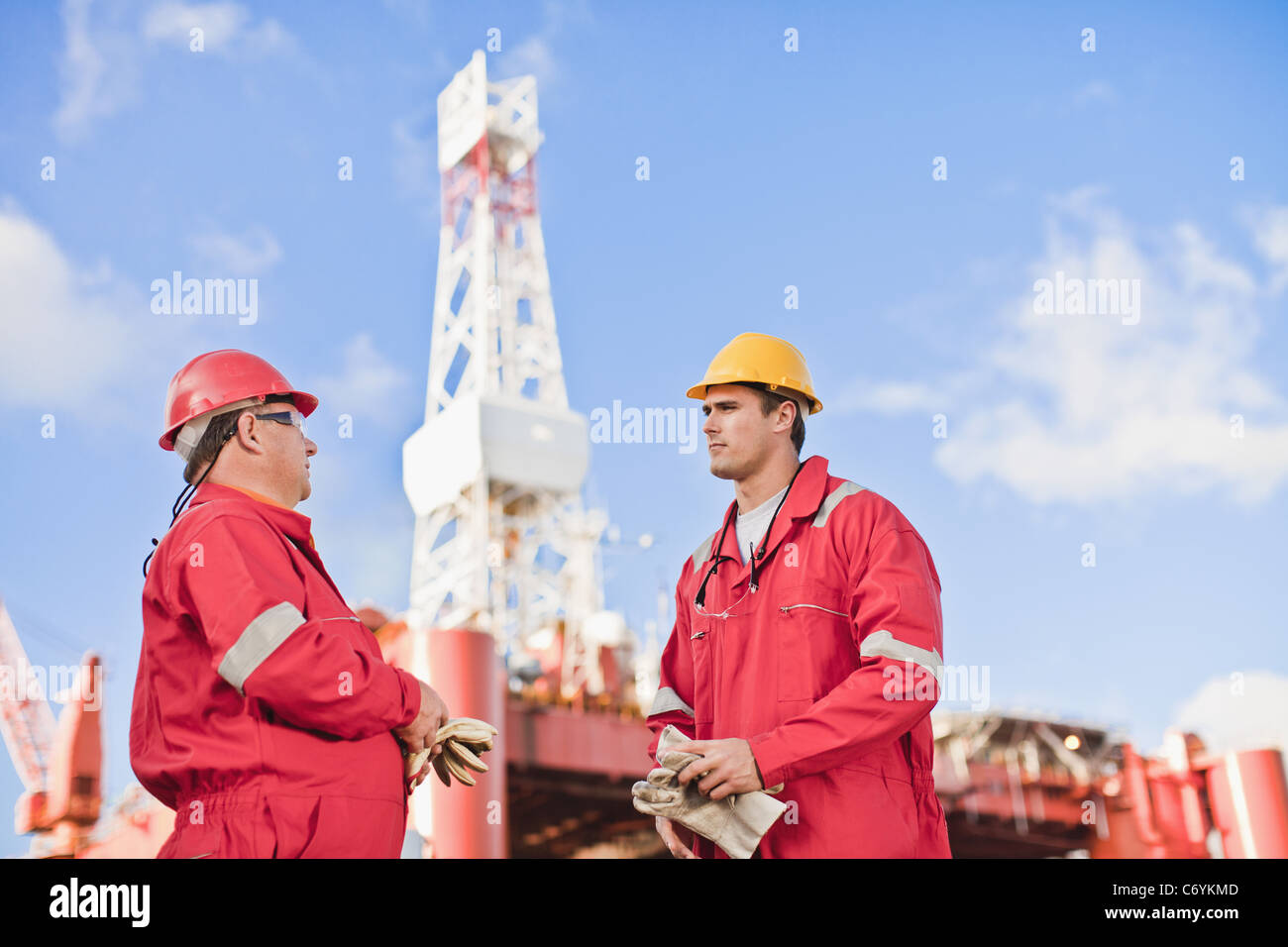 Workers talking on oil rig Stock Photo Alamy