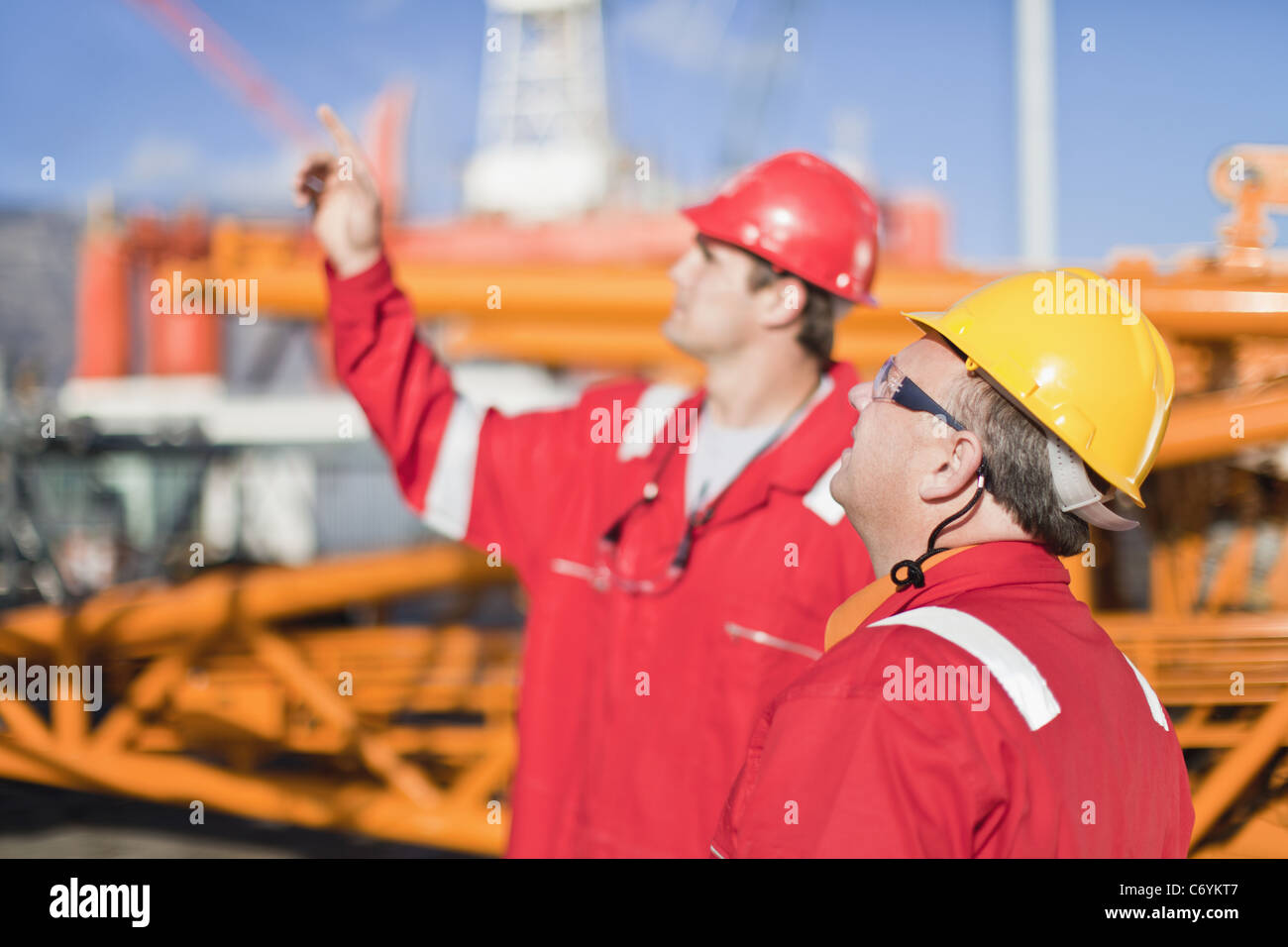 Workers talking on oil rig Stock Photo