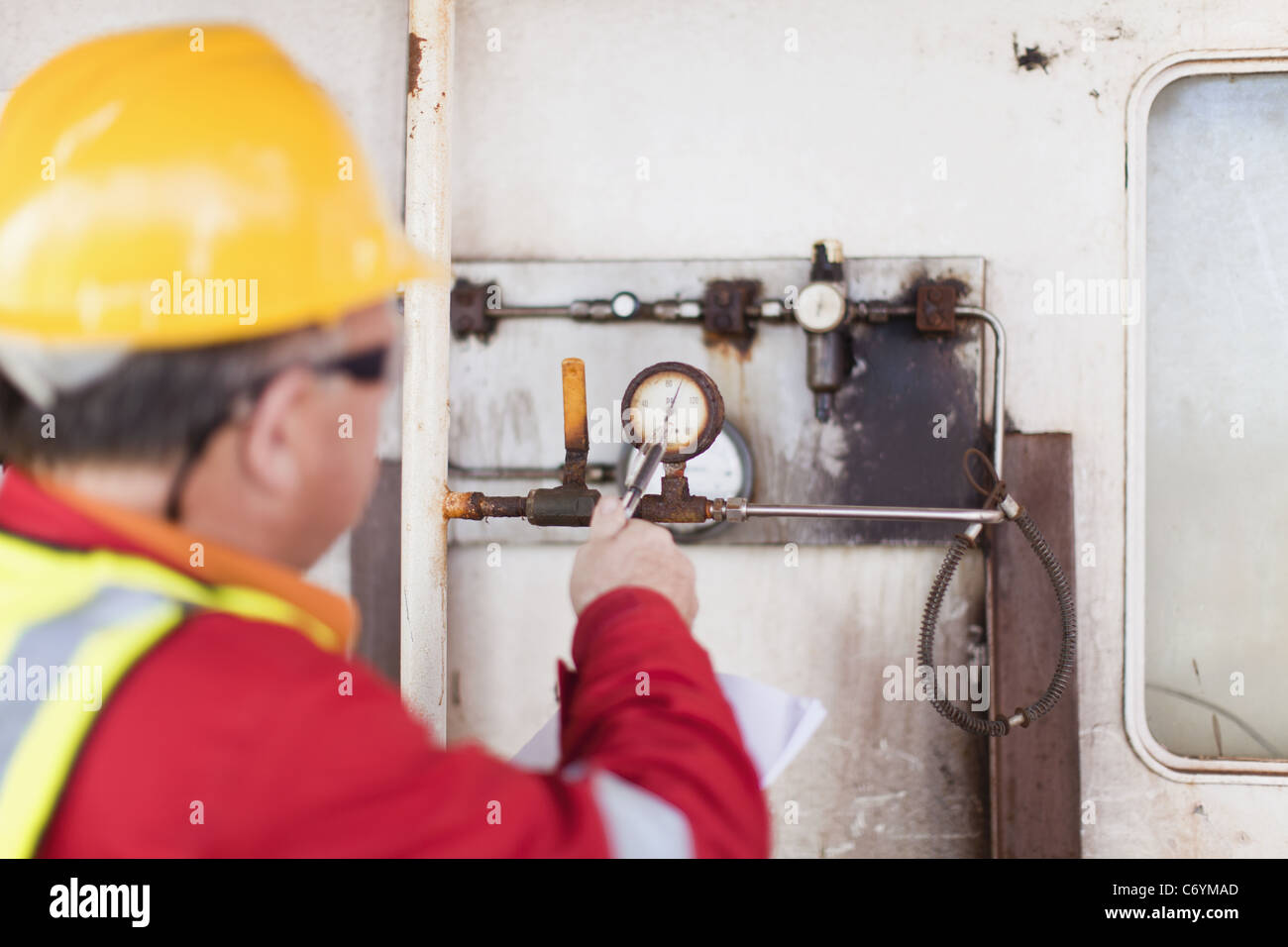 Worker checking gauge on oil rig Stock Photo Alamy