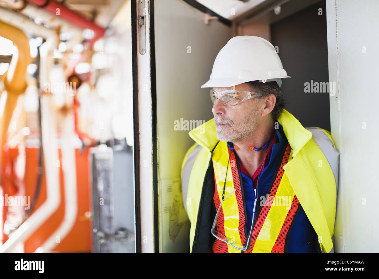 Worker standing in doorway on oil rig Stock Photo