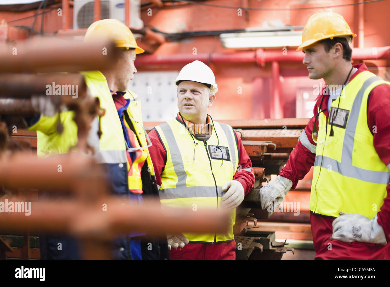 Workers talking on oil rig Stock Photo