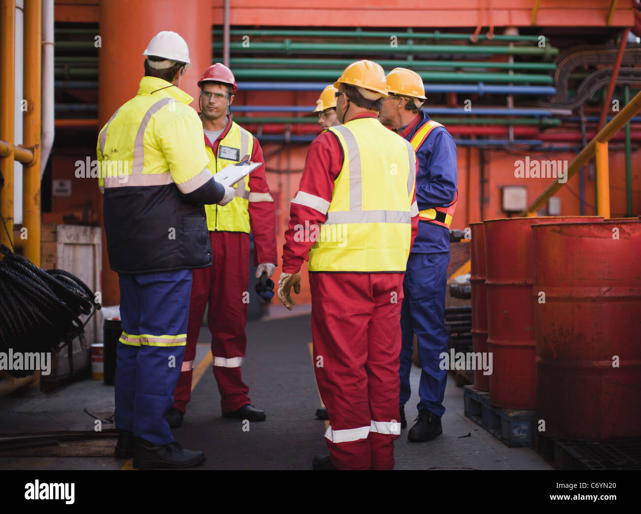 Workers talking on oil rig Stock Photo Alamy